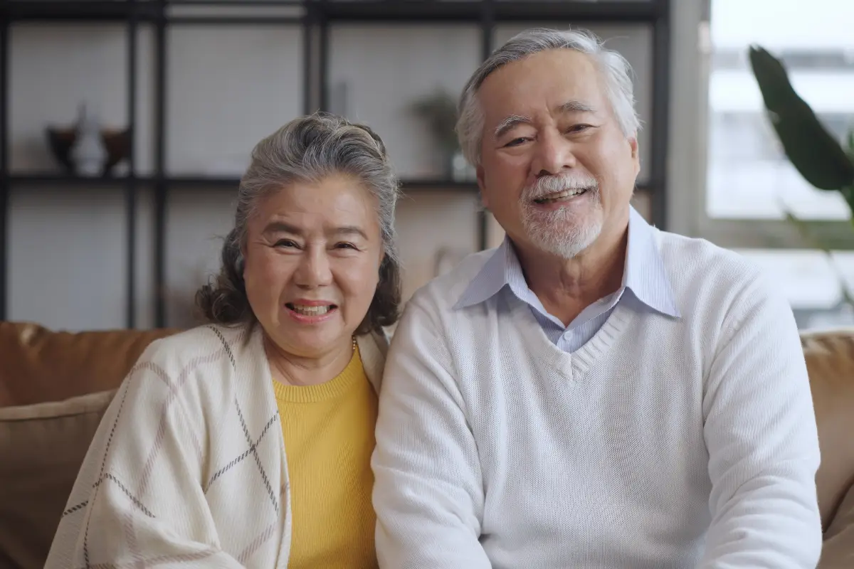 Older couple smiling at home, representing ageing and diabetes as common diseases that cause cataracts