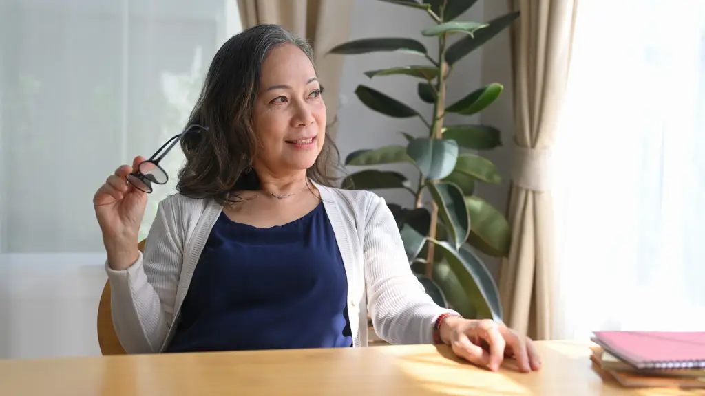 Woman holding reading glasses, representing cataract vs presbyopia and age-related vision changes.