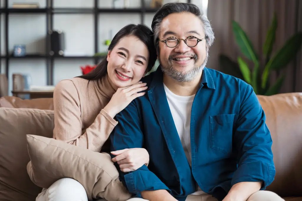 Smiling older Asian man with family support after cataract surgery and routine cataract treatment recovery.