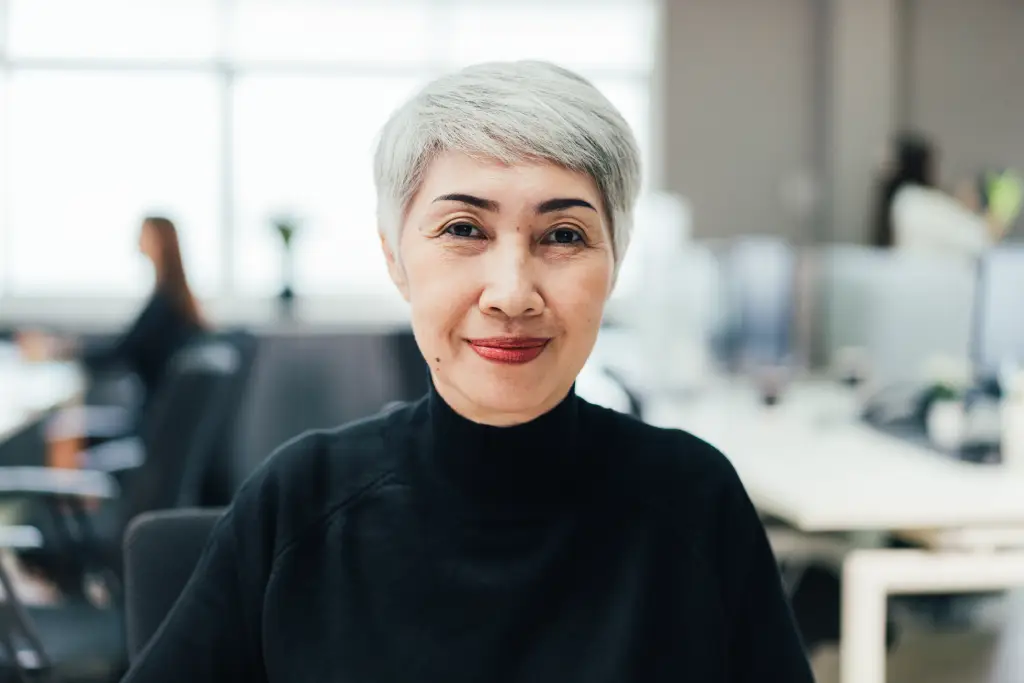 Woman in the office with clear vision after cataract surgery and follow-up eye care.