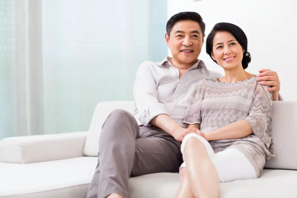 Older Asian couple relaxing at home after cataract surgery with clear, comfortable vision.