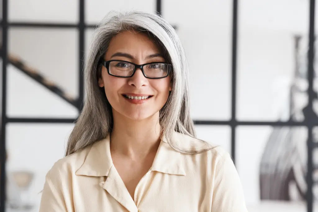 Older woman wearing glasses, representing presbyopia, cataracts, and age-related vision changes.